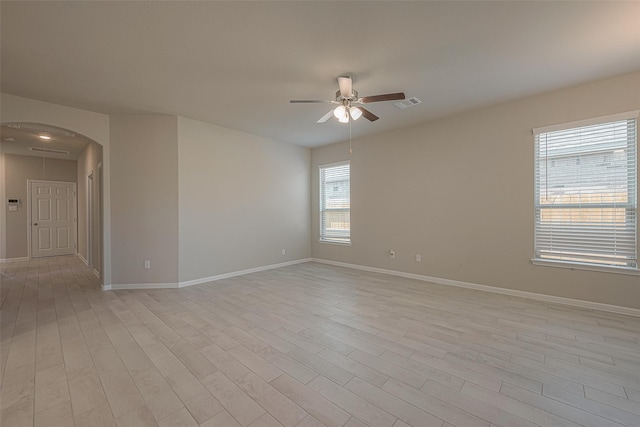 1464 Sundown Glen Ln, Katy, TX 77493 - unfurnished room featuring a ceiling fan, baseboards, light wood-style flooring, and arched walkways