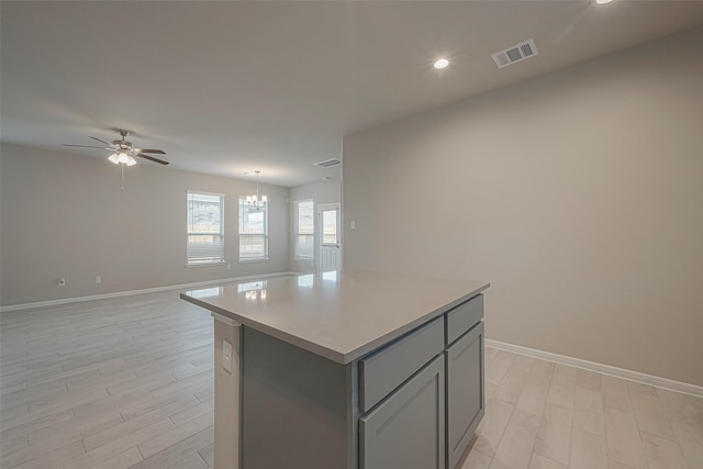 1464 Sundown Glen Ln, Katy, TX 77493 - kitchen featuring gray cabinets, a ceiling fan, a kitchen island, baseboards, and light wood-type flooring