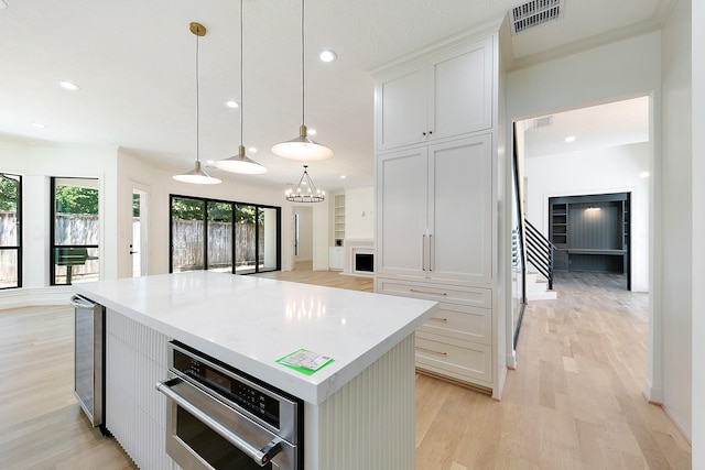4528 S Evergreen St, Bellaire, TX 77401 - kitchen with light wood-style floors, stainless steel oven, a center island, recessed lighting, and light countertops