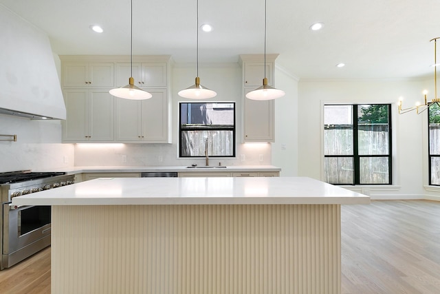 4528 S Evergreen St, Bellaire, TX 77401 - kitchen with stainless steel appliances, extractor fan, light wood-style flooring, light countertops, and a center island