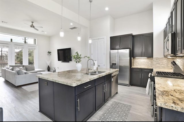 4104 Marina St, Houston, TX 77007 - kitchen featuring stainless steel appliances, a ceiling fan, open floor plan, light stone counters, and decorative backsplash