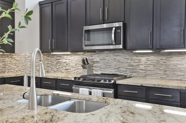 4104 Marina St, Houston, TX 77007 - kitchen with appliances with stainless steel finishes, backsplash, and light stone counters