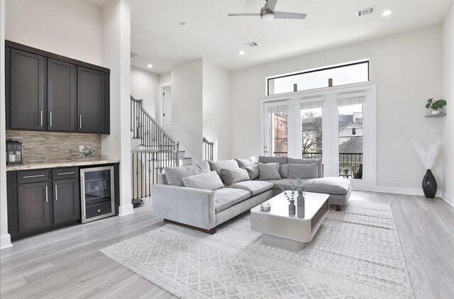 4104 Marina St, Houston, TX 77007 - living area with beverage cooler, light wood-style floors, a ceiling fan, bar, and a high ceiling