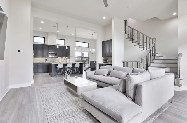 4104 Marina St, Houston, TX 77007 - living room featuring light wood-type flooring, recessed lighting, stairs, and a towering ceiling
