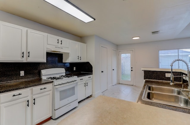 19603 Green Chase Ln, Houston, TX 77073 - kitchen with white gas stove, under cabinet range hood, white cabinets, and plenty of natural light