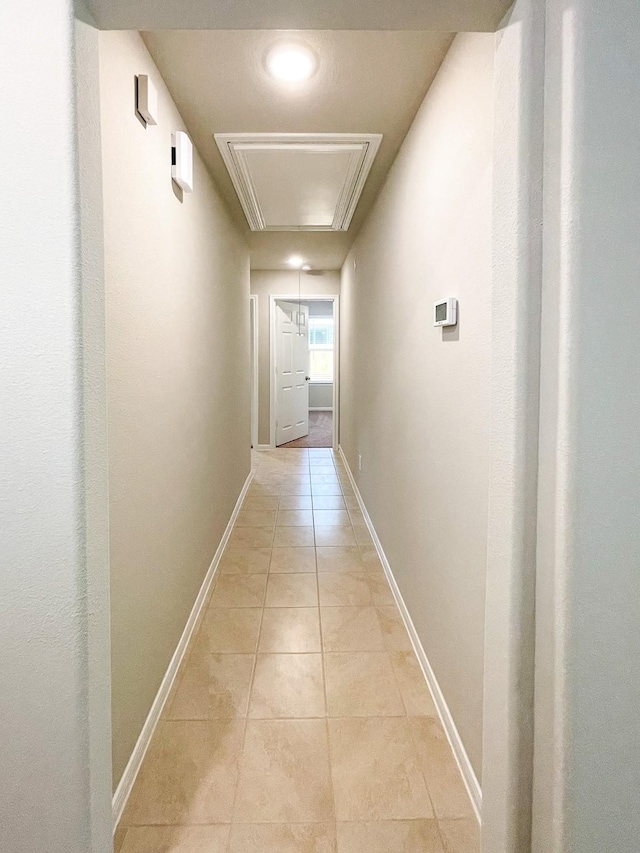 17807 Cappadocia Trl, Tomball, TX 77377 - hallway with attic access, light tile patterned floors, and baseboards