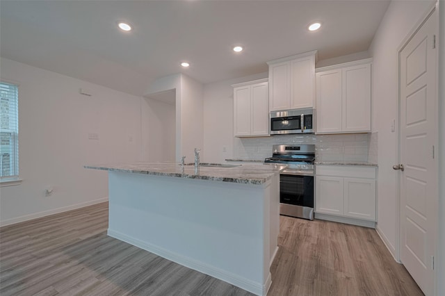 17807 Cappadocia Trl, Tomball, TX 77377 - kitchen featuring stainless steel appliances, light wood-style floors, light stone counters, and recessed lighting