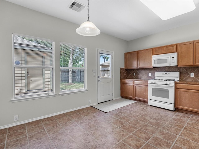 23807 Township Elm St, Spring, TX 77373 - kitchen featuring white appliances, tasteful backsplash, decorative light fixtures, baseboards, and brown cabinets