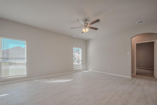 22807 Ephesus Ave, Tomball, TX 77377 - empty room with ceiling fan, arched walkways, light wood-style floors, and baseboards