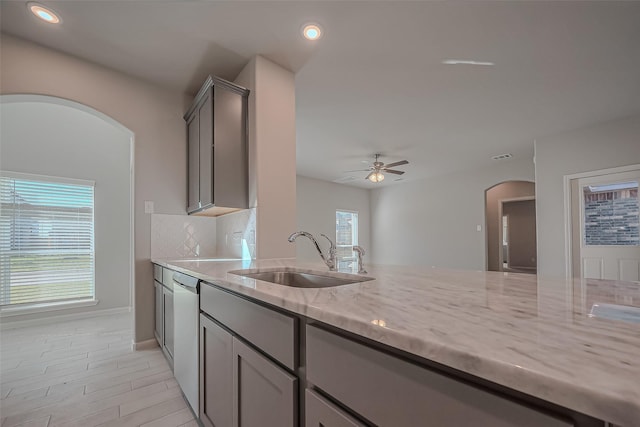 22807 Ephesus Ave, Tomball, TX 77377 - kitchen featuring arched walkways, a sink, light stone countertops, stainless steel dishwasher, and a ceiling fan