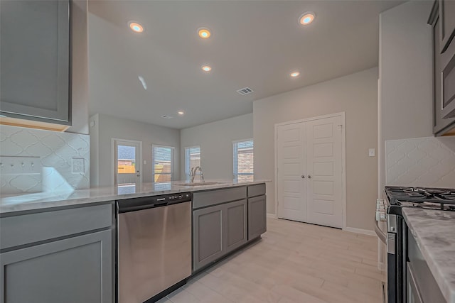 22807 Ephesus Ave, Tomball, TX 77377 - kitchen with stainless steel appliances, gray cabinetry, tasteful backsplash, light stone countertops, and recessed lighting