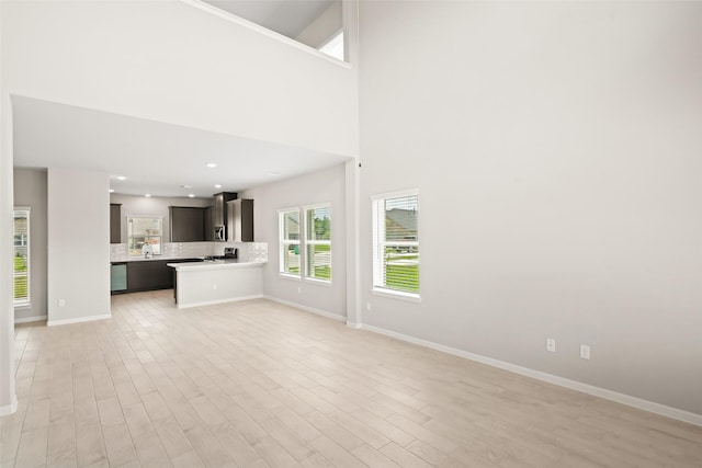 3211 Falling Brook Dr, Baytown, TX 77521 - unfurnished living room featuring light wood-type flooring and baseboards