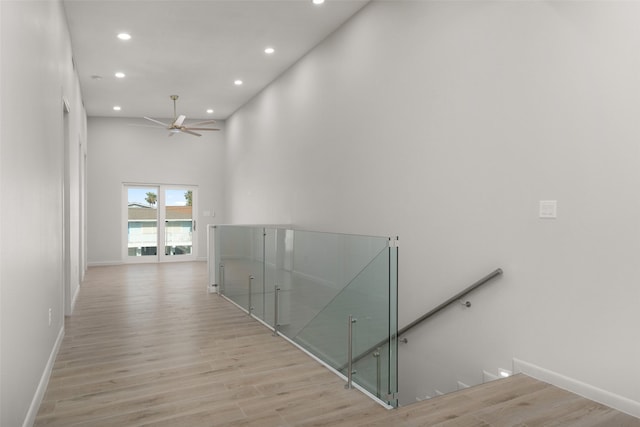 5606 Circe Cir Unit A, South Padre Island, TX 78597 - corridor featuring an upstairs landing, recessed lighting, light wood finished floors, baseboards, and a high ceiling