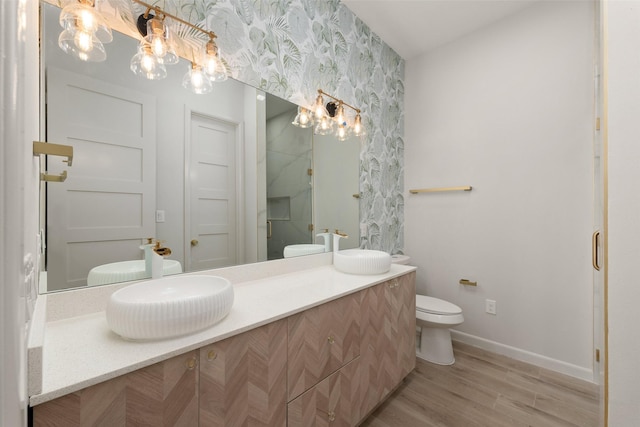5606 Circe Cir Unit A, South Padre Island, TX 78597 - full bathroom featuring wallpapered walls, toilet, baseboards, wood finished floors, and vanity