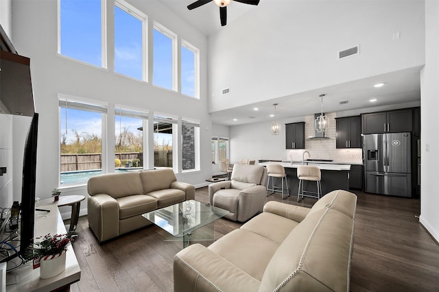 2334 Calm Channel Ct, Missouri City, TX 77459 - living area with a towering ceiling, dark wood-type flooring, a ceiling fan, plenty of natural light, and baseboards