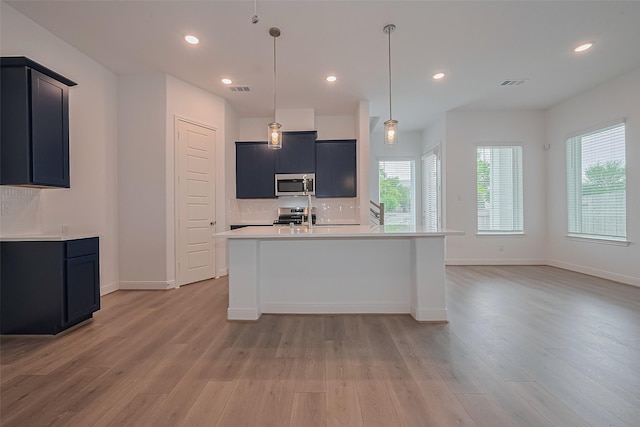 8933 Grovner Pl, Houston, TX 77055 - kitchen featuring stainless steel appliances, light wood-style floors, healthy amount of natural light, light countertops, and recessed lighting