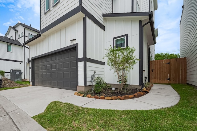 8933 Grovner Pl, Houston, TX 77055 - view of side of home featuring board and batten siding, a garage, driveway, and a gate