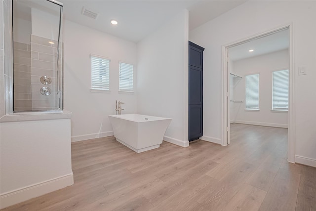 8933 Grovner Pl, Houston, TX 77055 - full bath with a freestanding bath, wood finished floors, a tile shower, baseboards, and recessed lighting