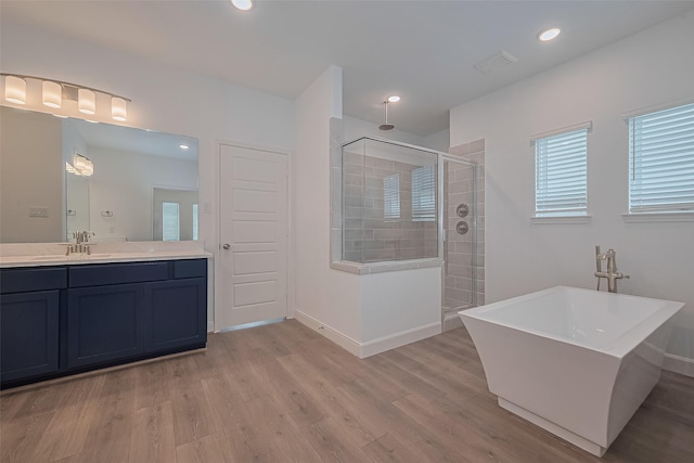 8933 Grovner Pl, Houston, TX 77055 - full bath with a tile shower, wood finished floors, vanity, a freestanding tub, and baseboards