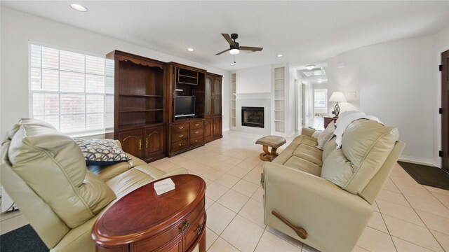 906 Juniper Ct, Tomball, TX 77375 - living area featuring a ceiling fan, light tile patterned flooring, a fireplace, built in shelves, and recessed lighting