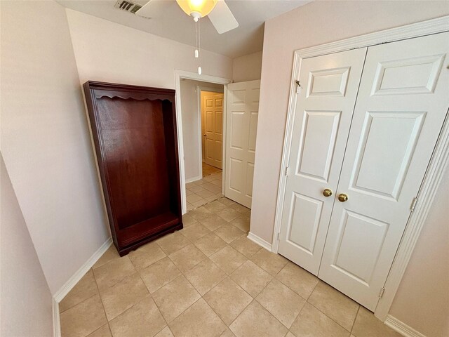 906 Juniper Ct, Tomball, TX 77375 - unfurnished bedroom with light tile patterned floors, baseboards, a closet, and a ceiling fan