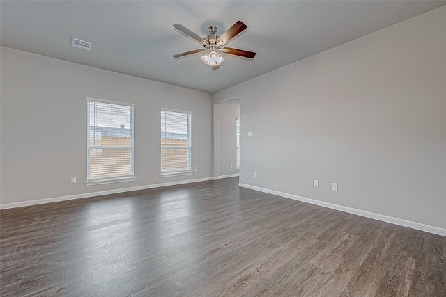 10155 Red Snapper Rd, Magnolia, TX 77354 - spare room featuring ceiling fan, dark wood-style floors, baseboards, and arched walkways