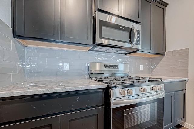 10155 Red Snapper Rd, Magnolia, TX 77354 - kitchen featuring stainless steel appliances, decorative backsplash, light stone counters, and gray cabinetry