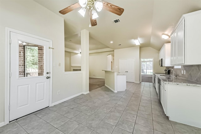 3506 Hickory Hill Ln, Montgomery, TX 77356 - kitchen with white cabinetry, light tile patterned floors, vaulted ceiling, a ceiling fan, and light stone counters