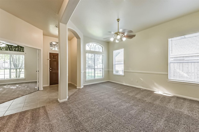 3506 Hickory Hill Ln, Montgomery, TX 77356 - spare room featuring carpet flooring, arched walkways, a ceiling fan, tile patterned flooring, and baseboards