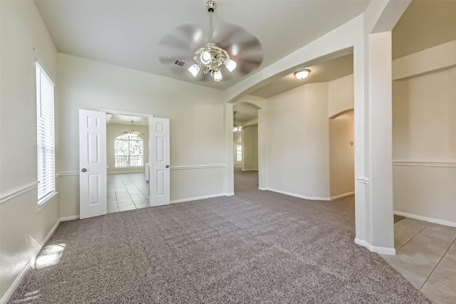 3506 Hickory Hill Ln, Montgomery, TX 77356 - unfurnished living room featuring ceiling fan, arched walkways, carpet flooring, tile patterned flooring, and baseboards