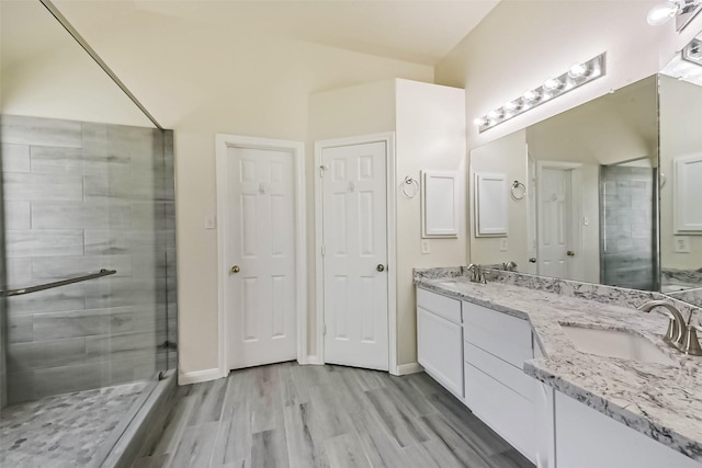3506 Hickory Hill Ln, Montgomery, TX 77356 - bathroom featuring double vanity, a stall shower, wood finished floors, and baseboards