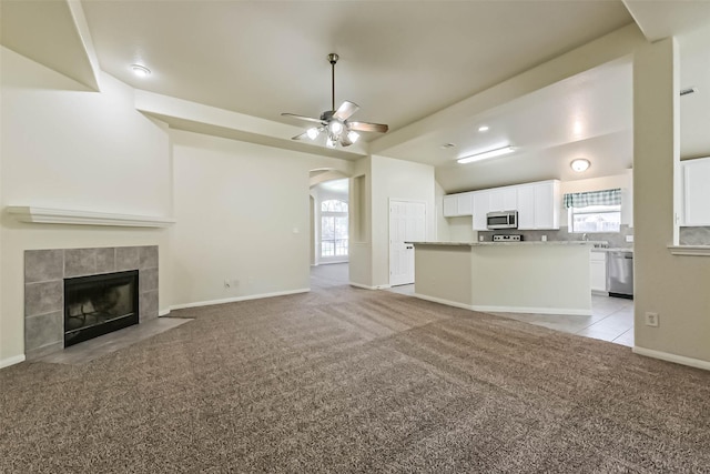 3506 Hickory Hill Ln, Montgomery, TX 77356 - unfurnished living room featuring light colored carpet, healthy amount of natural light, ceiling fan, and arched walkways