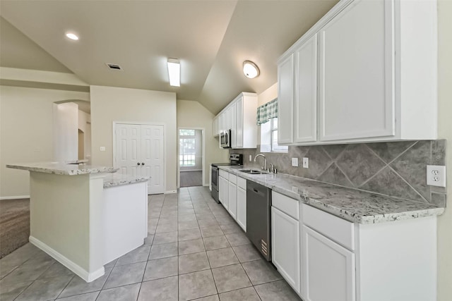 3506 Hickory Hill Ln, Montgomery, TX 77356 - kitchen with stainless steel appliances, a sink, vaulted ceiling, white cabinets, and a center island