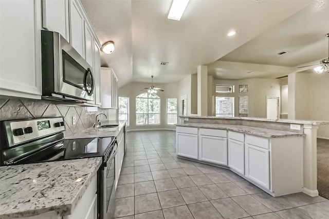 3506 Hickory Hill Ln, Montgomery, TX 77356 - kitchen featuring stainless steel appliances, a ceiling fan, light tile patterned floors, white cabinetry, and lofted ceiling