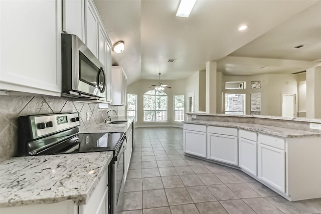3506 Hickory Hill Ln, Montgomery, TX 77356 - kitchen with appliances with stainless steel finishes, a sink, light tile patterned floors, decorative backsplash, and white cabinetry