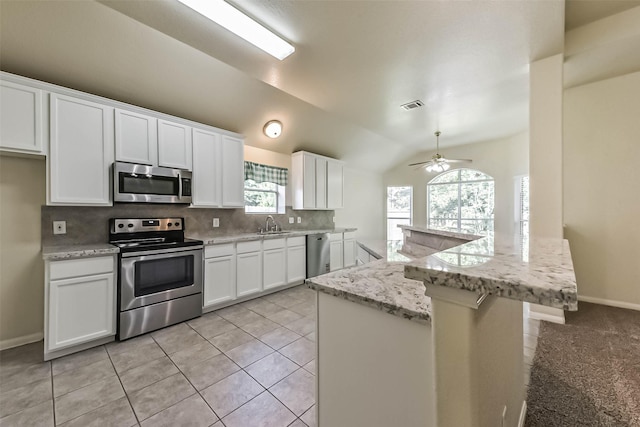 3506 Hickory Hill Ln, Montgomery, TX 77356 - kitchen featuring appliances with stainless steel finishes, backsplash, white cabinets, a ceiling fan, and lofted ceiling