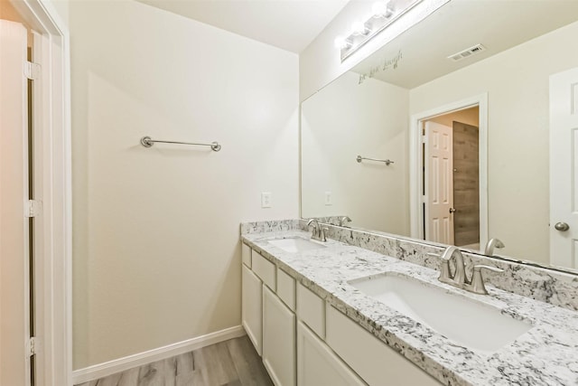 3506 Hickory Hill Ln, Montgomery, TX 77356 - full bathroom featuring double vanity, wood finished floors, and baseboards