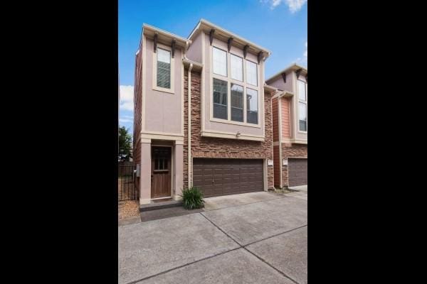 1042 W 23rd St Unit D, Houston, TX 77008 - view of front of home with a garage, driveway, and stone siding