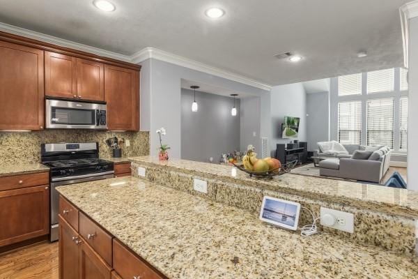 1042 W 23rd St Unit D, Houston, TX 77008 - kitchen with appliances with stainless steel finishes, crown molding, light stone counters, decorative backsplash, and light wood finished floors