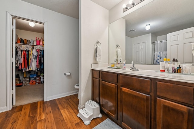 850 Driftwood Ln, La Marque, TX 77568 - bathroom featuring toilet, vanity, wood finished floors, baseboards, and a spacious closet