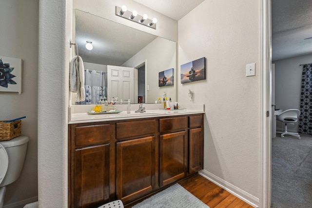 850 Driftwood Ln, La Marque, TX 77568 - bathroom with toilet, vanity, baseboards, wood finished floors, and a textured wall
