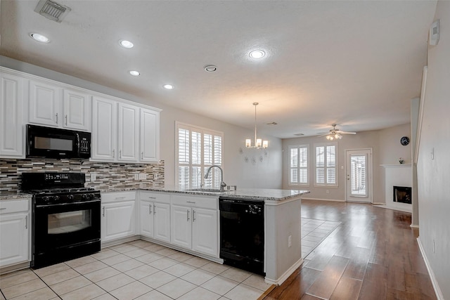 2710 Marigny Dr, Houston, TX 77014 - kitchen featuring black appliances, a sink, a peninsula, plenty of natural light, and recessed lighting