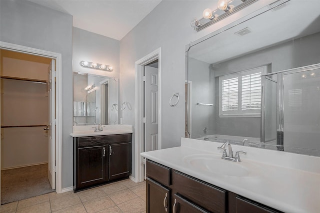 2710 Marigny Dr, Houston, TX 77014 - full bath featuring vanity, tile patterned flooring, a stall shower, a garden tub, and a walk in closet