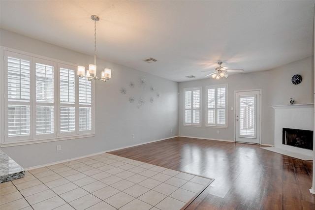 2710 Marigny Dr, Houston, TX 77014 - unfurnished living room with ceiling fan, a chandelier, wood finished floors, a fireplace, and baseboards