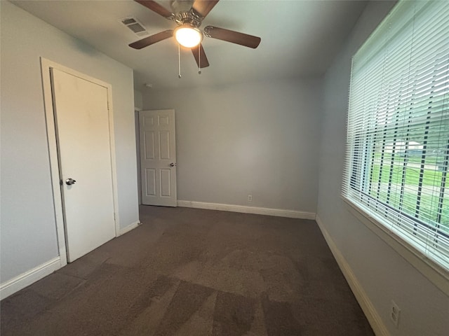 6210 Annunciation St, Houston, TX 77016 - unfurnished bedroom featuring dark carpet, baseboards, and ceiling fan