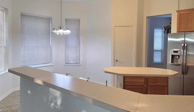 11143 Dawn Harvest Dr, Houston, TX 77064 - kitchen with stainless steel fridge with ice dispenser, a chandelier, light countertops, hanging light fixtures, and baseboards