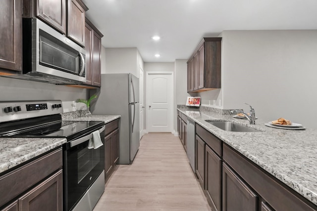 6230 El Cobre Dr, Houston, TX 77048 - kitchen with appliances with stainless steel finishes, a sink, dark brown cabinetry, and recessed lighting