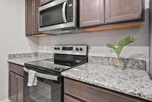 6230 El Cobre Dr, Houston, TX 77048 - kitchen featuring appliances with stainless steel finishes, dark brown cabinets, and light stone counters