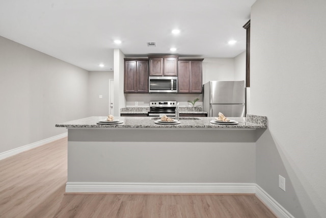 6230 El Cobre Dr, Houston, TX 77048 - kitchen featuring stainless steel appliances, dark brown cabinetry, light wood-style floors, baseboards, and recessed lighting