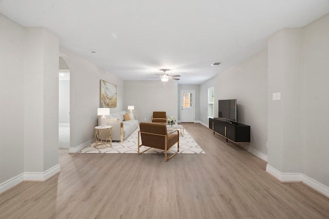 6230 El Cobre Dr, Houston, TX 77048 - living room with light wood-type flooring, arched walkways, ceiling fan, and baseboards